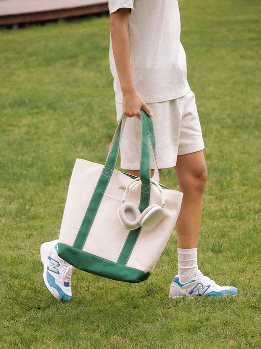 AROSRIS Canvas Tennis Tote in Varsity Green — street style shot showing structured silhouette and dual handle carry