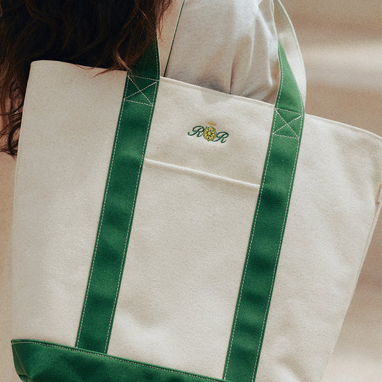 AROSRIS Structured Canvas Tennis Tote in Varsity Green — close-up showing PVC-reinforced structure, crest embroidery and zip-top closure