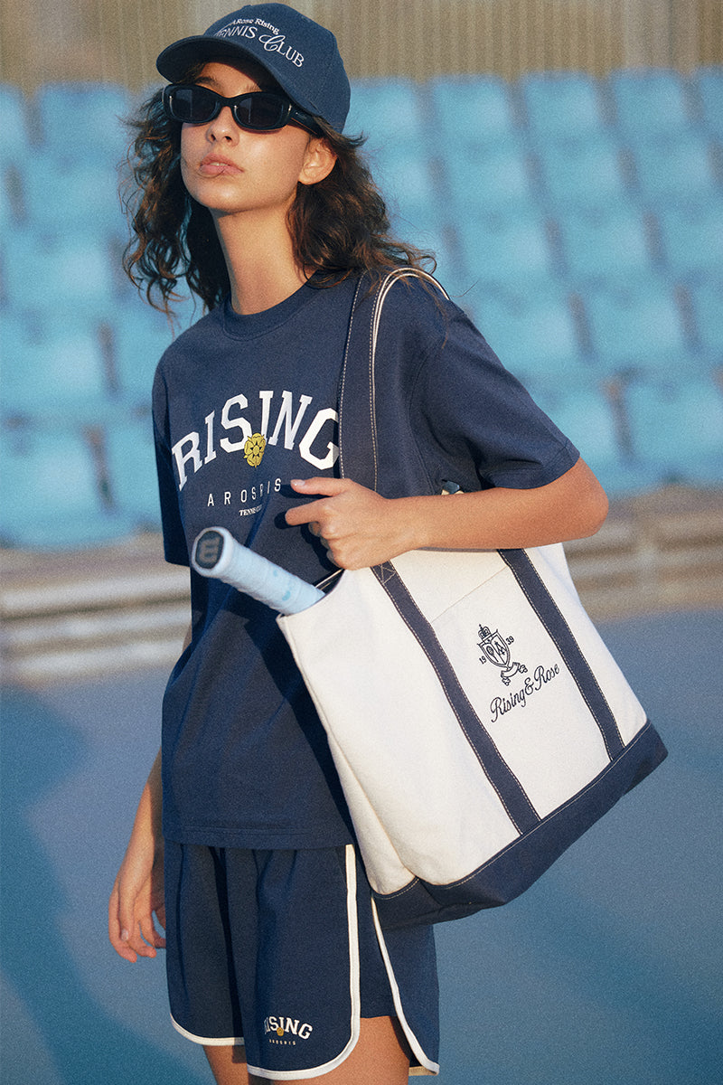 AROSRIS Heritage Canvas Tote styled with athletic outfit — showing court-to-city versatility and shoulder carry