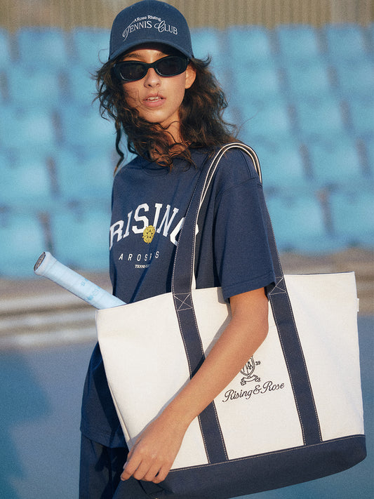 AROSRIS Heritage Embroidered Canvas Tote — street style shot showing oversized structured silhouette and heritage embroidery detail