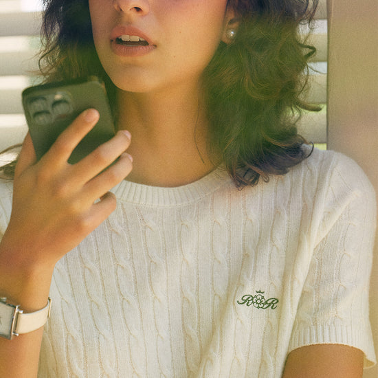 AROSRIS Retro Cable Knit Short Sleeve in Cream Beige — close-up showing 3D cable knit pattern and embroidered logo detail