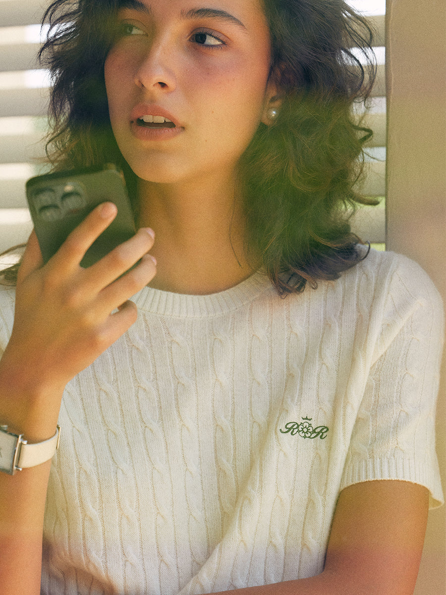 AROSRIS Retro Cable Knit Short Sleeve in Cream Beige — close-up showing 3D cable knit pattern and embroidered logo detail