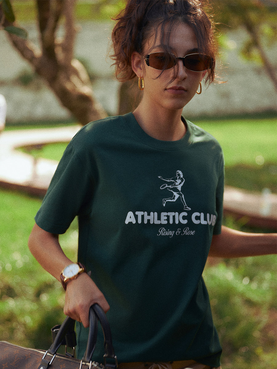 AROSRIS Kay Stammers Tribute Tee in Varsity Green — outdoor lifestyle shot showing premium Xinjiang cotton drape and graphic detail
