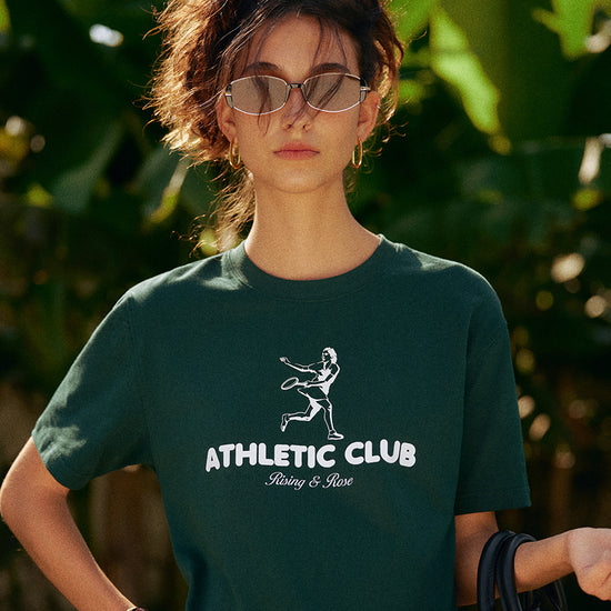 AROSRIS Kay Stammers Tribute Tee — side profile showing drop-shoulder cut and Varsity Green vintage hue in natural light