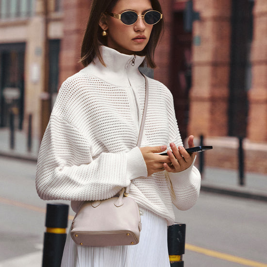 AROSRIS Old Money Hollow-Out Cotton Half-Zip Knit in Mist White — full body street style showing openwork cable pattern and half-zip collar