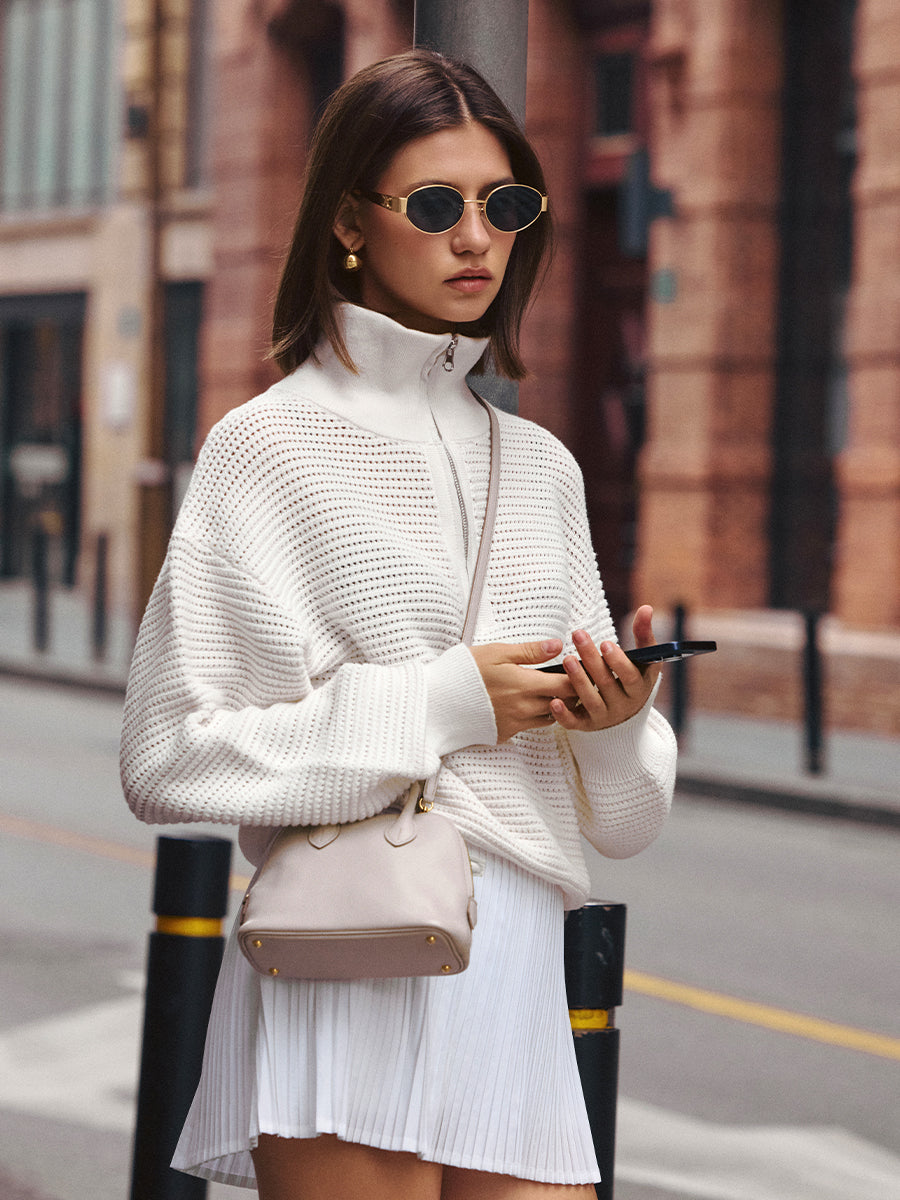 AROSRIS Old Money Hollow-Out Cotton Half-Zip Knit in Mist White — full body street style showing openwork cable pattern and half-zip collar