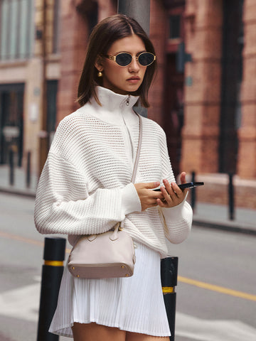AROSRIS Old Money Hollow-Out Cotton Half-Zip Knit in Mist White — full body street style showing openwork cable pattern and half-zip collar