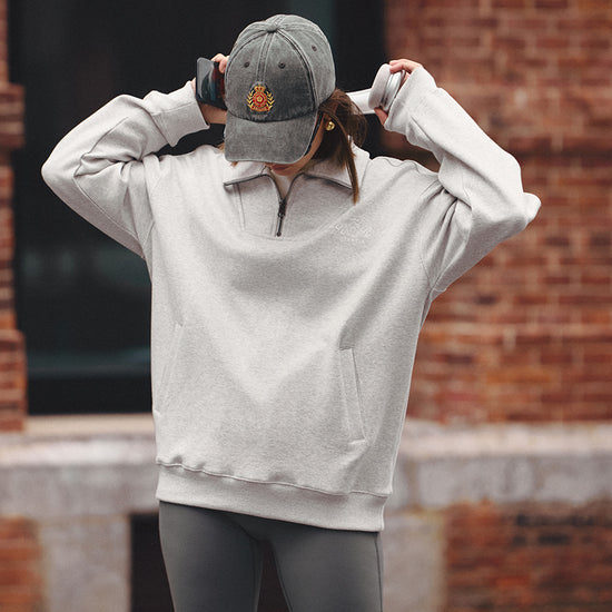 AROSRIS Tennis Club Distressed Cap in Vintage Charcoal — full body lifestyle shot styled with sweatshirt and headphones