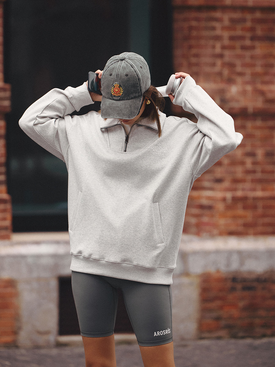 AROSRIS Tennis Club Distressed Cap in Vintage Charcoal — full body lifestyle shot styled with sweatshirt and headphones