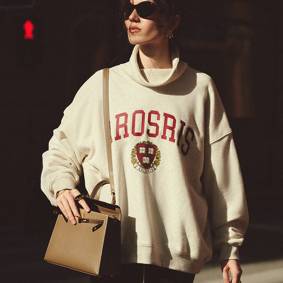 AROSRIS The Princess Mock Neck Varsity Sweatshirt in Varsity Grey — full body street style showing oversized silhouette and varsity crest graphic