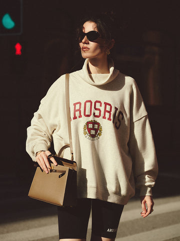 AROSRIS The Princess Mock Neck Varsity Sweatshirt in Varsity Grey — full body street style showing oversized silhouette and varsity crest graphic