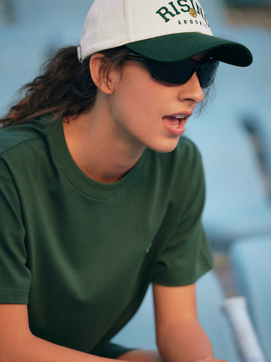 AROSRIS Vintage Embroidered Dad Hat styled with matching green athletic set — showing off-duty sporty aesthetic