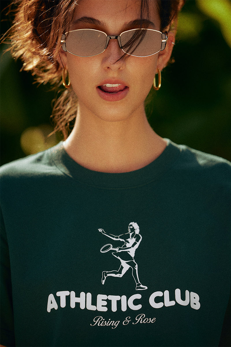 AROSRIS Kay Stammers Tribute Vintage Tennis Graphic Tee in Varsity Green — close-up showing Athletic Club tribute graphic and drop-shoulder silhouette