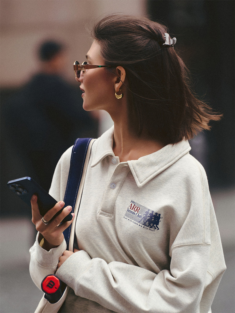 AROSRIS Tennis Club Polo Sweatshirt styled with high-waist bottoms — showing leg-lengthening cropped effect in Oatmeal Heather