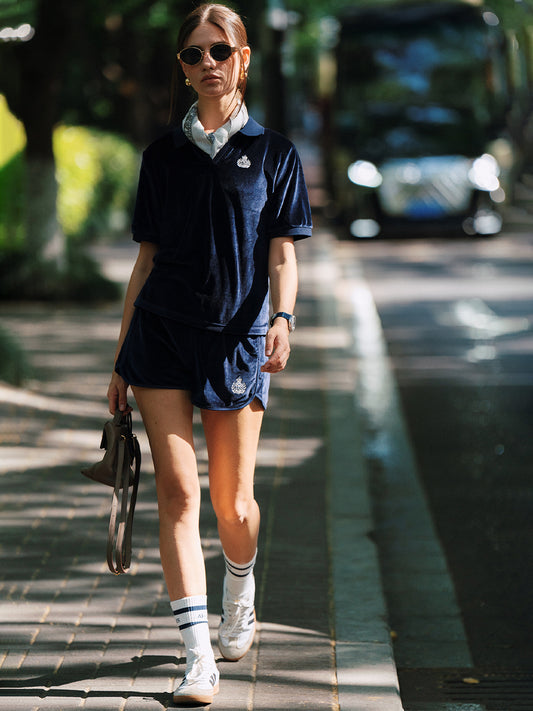 AROSRIS Holiday Velvet Shorts in navy — lifestyle shot showing relaxed fit and vintage badge embroidery