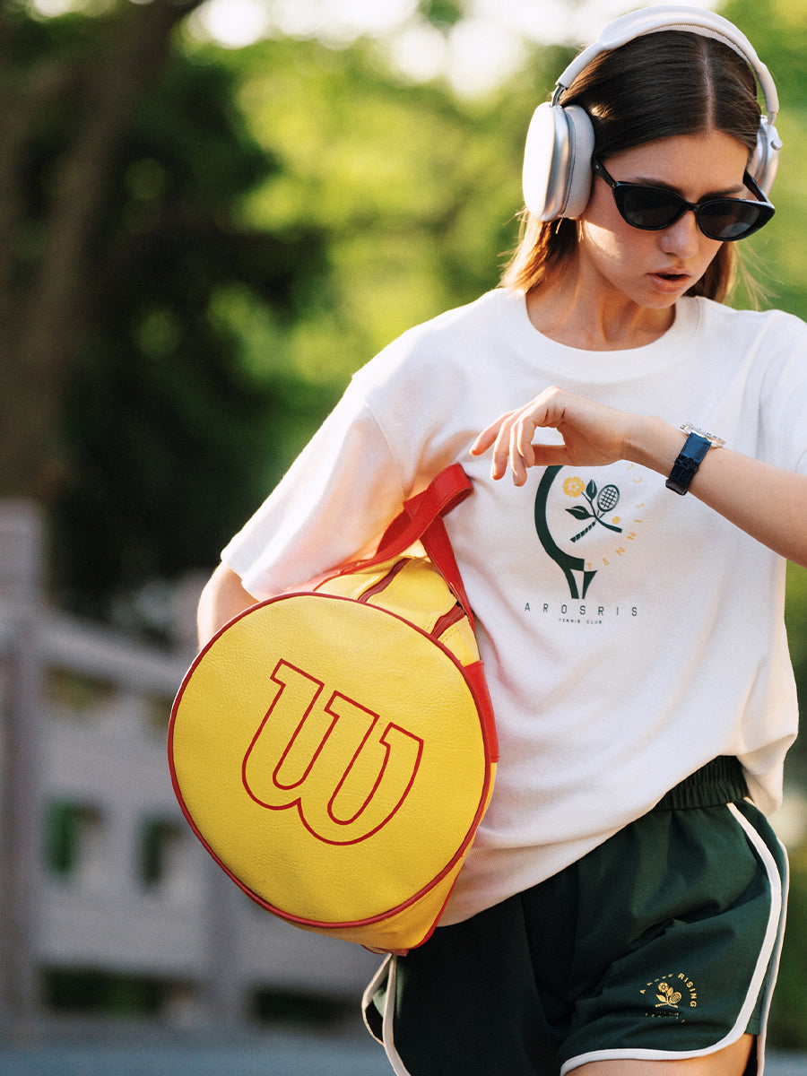 AROSRIS Morning Run Waffle Knit Graphic Tee in white — model with tennis racket bag, sporty street style