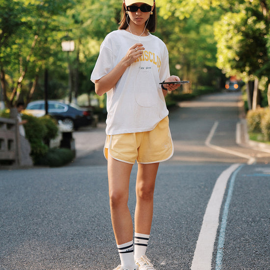 AROSRIS Avenue Cotton Shorts in forest green — outdoor lifestyle shot showing relaxed A-line fit
