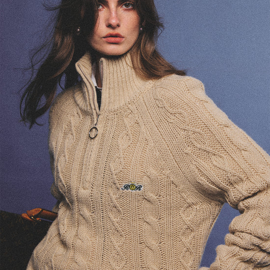 Arosris oatmeal latte cable knit half-zip sweater elegantly styled on a model over a crisp white collared shirt, capturing an effortless 90s preppy and old money academia aesthetic.