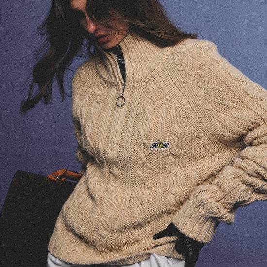 Arosris oatmeal latte cable knit half-zip sweater elegantly styled on a model over a crisp white collared shirt, capturing an effortless 90s preppy and old money academia aesthetic.