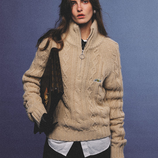 Arosris oatmeal latte cable knit half-zip sweater elegantly styled on a model over a crisp white collared shirt, capturing an effortless 90s preppy and old money academia aesthetic.