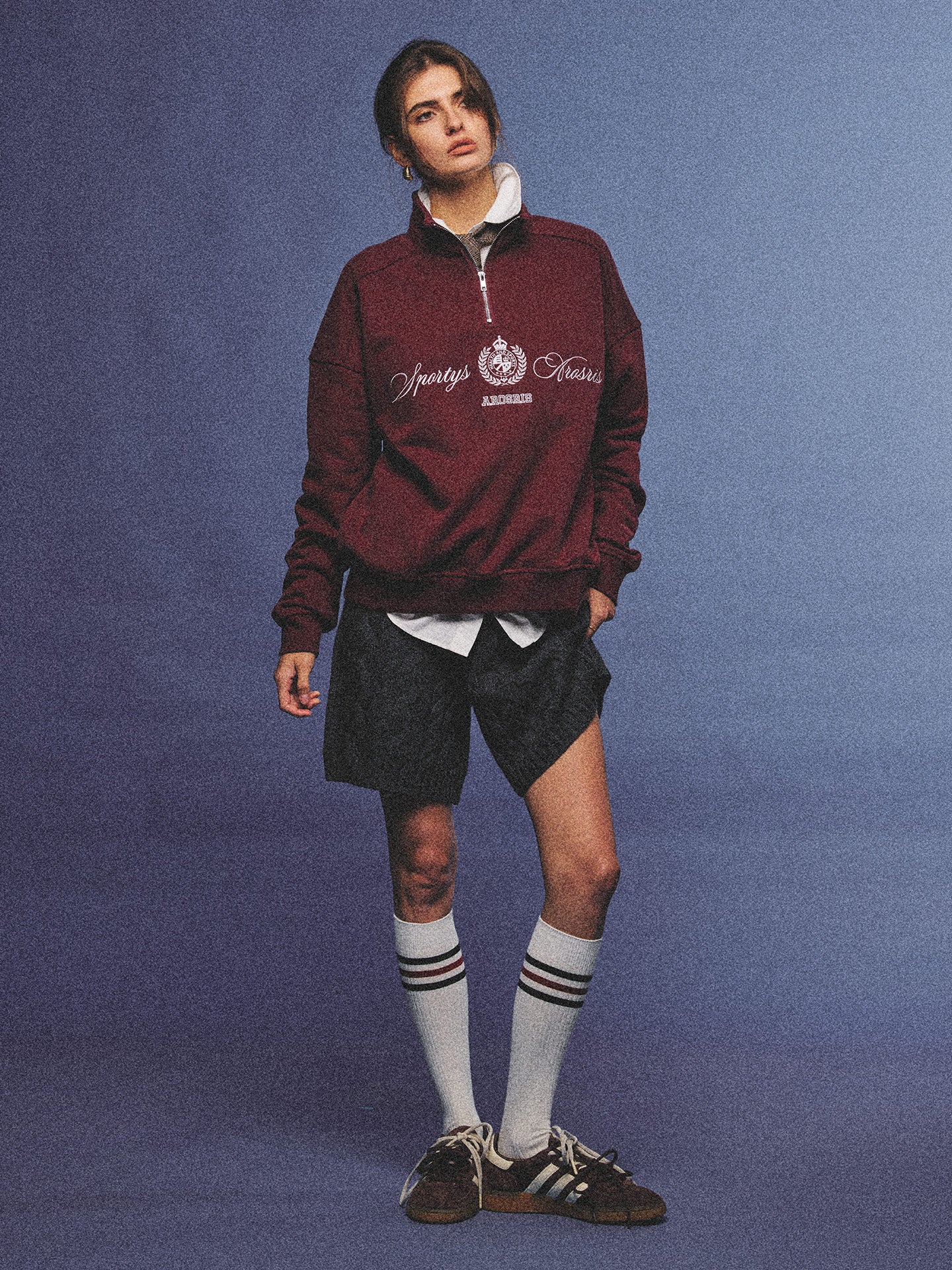 Arosris burgundy vintage-inspired campus half-zip sweatshirt with a custom crest embroidery, styled with biker shorts and retro sneakers for an effortless 90s sporty-chic aesthetic.