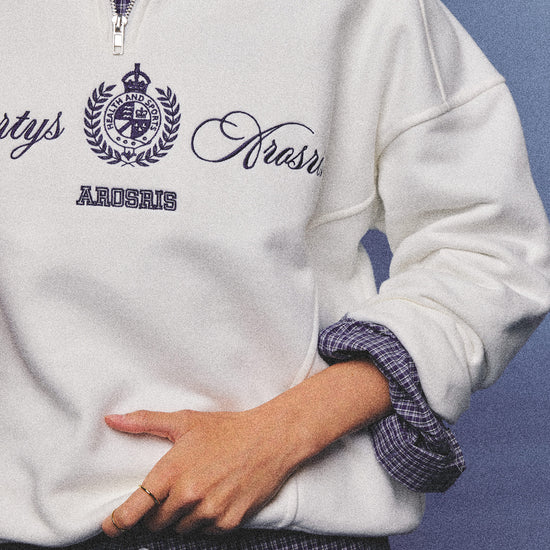 Arosris ecru vintage-inspired campus half-zip sweatshirt featuring a structured heavyweight cotton feel, styled for an unstudied 90s athletic varsity aesthetic.