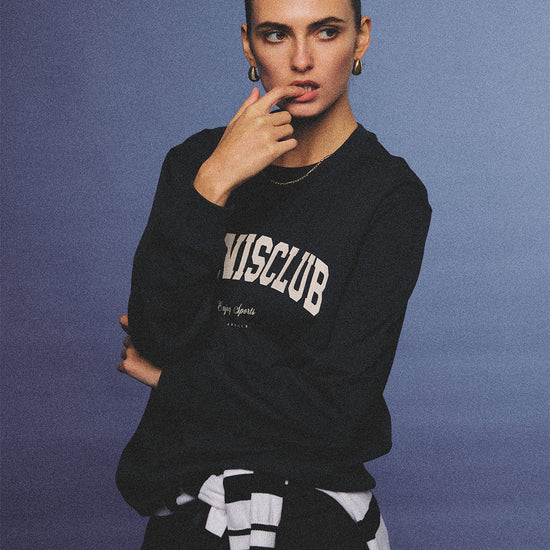 Arosris navy campus long sleeve t-shirt crafted from premium Pima cotton, featuring a vintage 'TENNISCLUB' graphic, elegantly styled with layered activewear for an effortless 90s sporty-chic aesthetic.