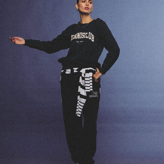 Arosris navy campus long sleeve t-shirt crafted from premium Pima cotton, featuring a vintage 'TENNISCLUB' graphic, elegantly styled with layered activewear for an effortless 90s sporty-chic aesthetic.