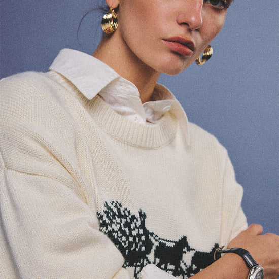 Arosris cream vintage-inspired carriage graphic wool blend sweater elegantly styled on a model with retro accessories, capturing an old money and preppy country club aesthetic.