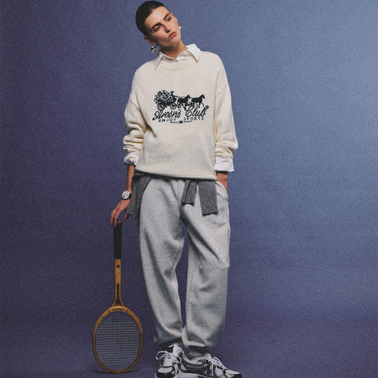 Arosris cream vintage-inspired carriage graphic wool blend sweater elegantly styled on a model with retro accessories, capturing an old money and preppy country club aesthetic.
