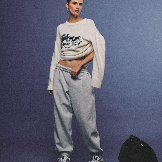 Arosris cream vintage-inspired carriage graphic wool blend sweater elegantly styled on a model with retro accessories, capturing an old money and preppy country club aesthetic.