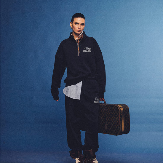 Arosris navy country club half-zip sweatshirt, expertly layered with a classic trench coat and vintage accessories for an effortless 90s sporty-rich aesthetic.