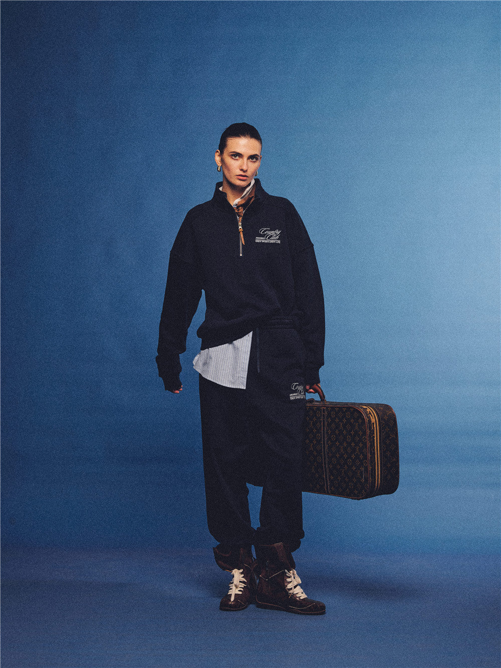 Arosris navy country club half-zip sweatshirt, expertly layered with a classic trench coat and vintage accessories for an effortless 90s sporty-rich aesthetic.