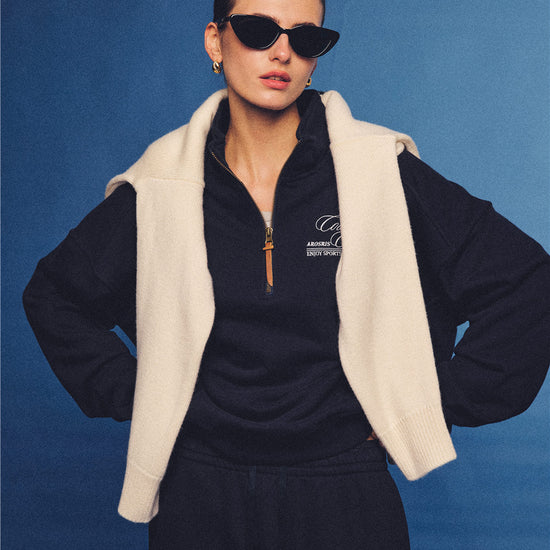 Arosris navy country club half-zip sweatshirt, expertly layered with a classic trench coat and vintage accessories for an effortless 90s sporty-rich aesthetic.