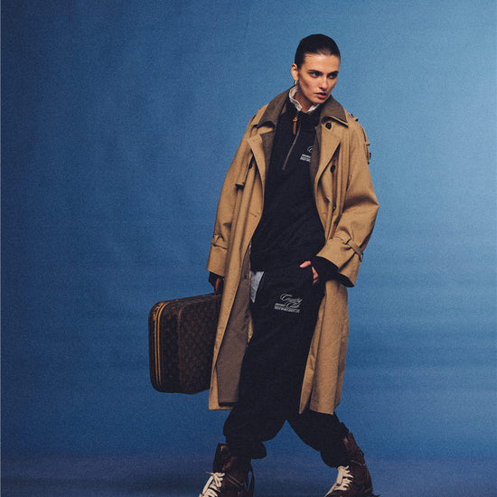 Arosris navy country club half-zip sweatshirt, expertly layered with a classic trench coat and vintage accessories for an effortless 90s sporty-rich aesthetic.