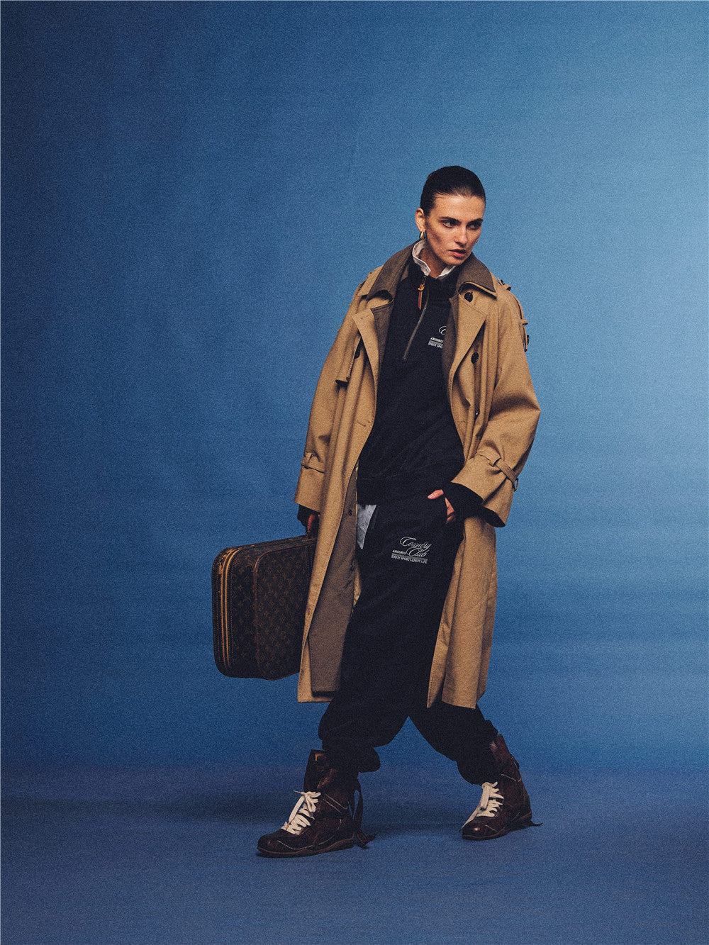 Arosris navy country club half-zip sweatshirt, expertly layered with a classic trench coat and vintage accessories for an effortless 90s sporty-rich aesthetic.
