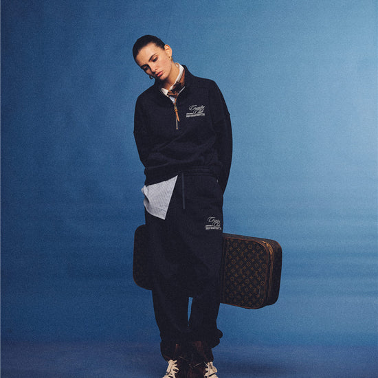 Arosris navy country club relaxed sweatpants, styled with a classic trench coat and vintage accessories for an effortless 90s sporty-rich aesthetic.