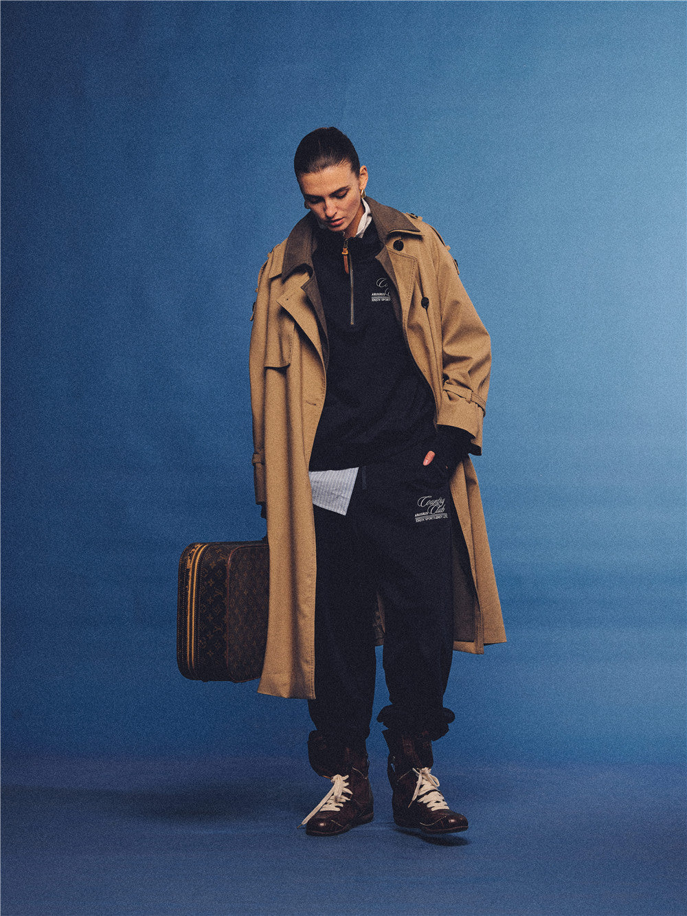 Arosris navy country club relaxed sweatpants, styled with a classic trench coat and vintage accessories for an effortless 90s sporty-rich aesthetic.