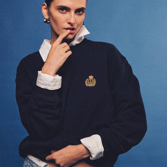 Arosris navy offshore crest crewneck sweatshirt with gold embroidery, styled with vintage accessories for an effortless 90s sporty-rich country club aesthetic.