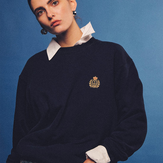 Arosris navy offshore crest crewneck sweatshirt with gold embroidery, styled with vintage accessories for an effortless 90s sporty-rich country club aesthetic.