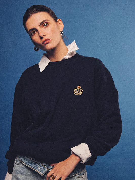 Arosris navy offshore crest crewneck sweatshirt with gold embroidery, styled with vintage accessories for an effortless 90s sporty-rich country club aesthetic.