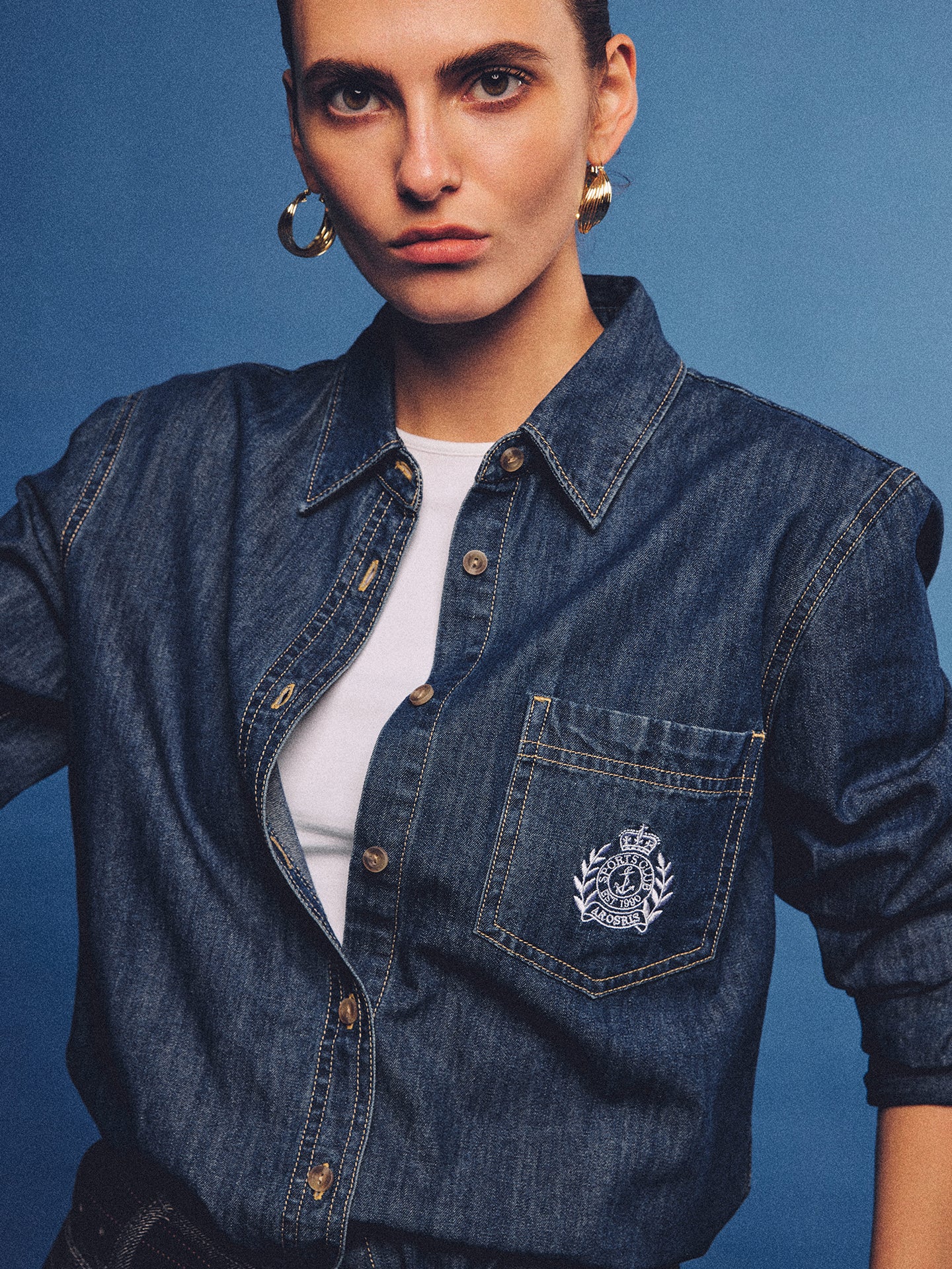 Arosris washed blue offshore crest denim shirt with nautical embroidery, styled as a cohesive 90s vintage double-denim outfit.