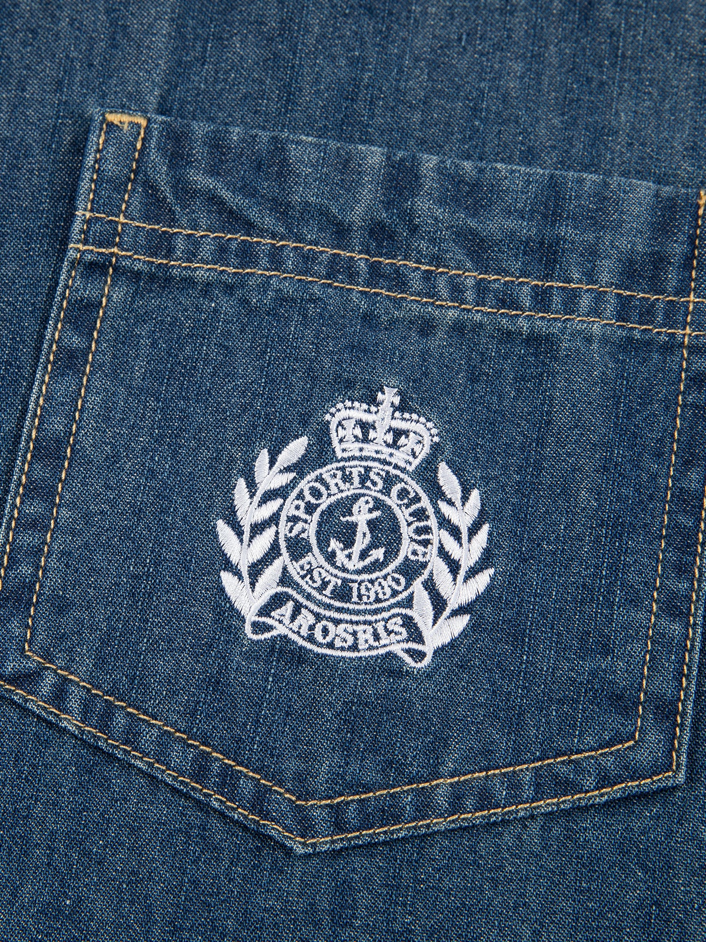 Arosris washed blue offshore crest denim shirt showcasing a classic fit, premium vintage wash, and signature nautical anchor chest pocket embroidery.
