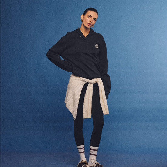 Arosris navy offshore crest shawl collar sweatshirt, styled with a tied sweater and retro sneakers for an effortless 90s vintage country club aesthetic.