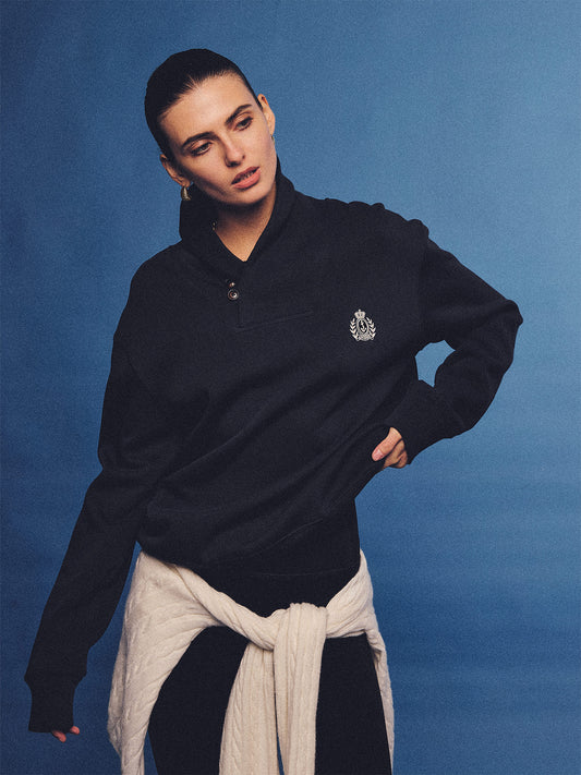 Arosris navy offshore crest shawl collar sweatshirt, styled with a tied sweater and retro sneakers for an effortless 90s vintage country club aesthetic.