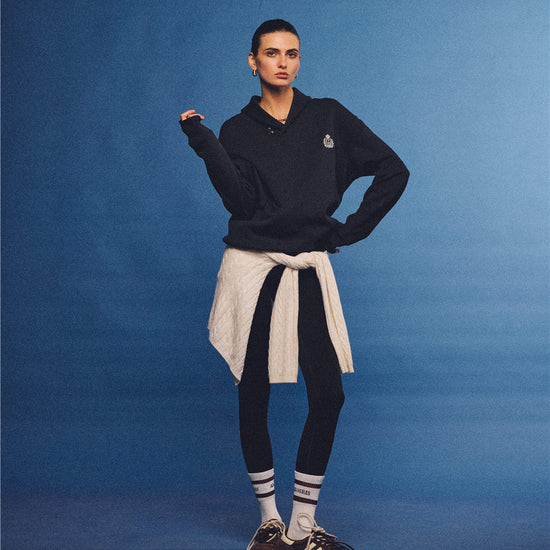 Arosris navy offshore crest shawl collar sweatshirt, styled with a tied sweater and retro sneakers for an effortless 90s vintage country club aesthetic.