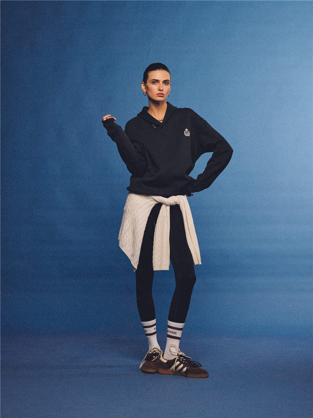 Arosris navy offshore crest shawl collar sweatshirt, styled with a tied sweater and retro sneakers for an effortless 90s vintage country club aesthetic.