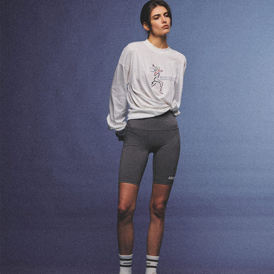 Arosris charcoal grey relaxed fit cotton t-shirt featuring a vintage 'ARR RIDING' equestrian horse graphic, styled on a model with wide-leg denim and a suede tote bag for an effortless 90s country club off-duty aesthetic.