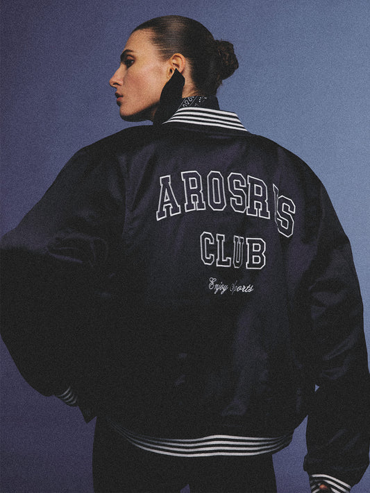 Arosris midnight navy high-gloss satin padded bomber jacket featuring a bold vintage club back embroidery, styled for an effortless 90s sporty-chic varsity aesthetic.