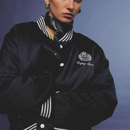 Arosris midnight navy high-gloss satin padded bomber jacket featuring a bold vintage club back embroidery, styled for an effortless 90s sporty-chic varsity aesthetic.